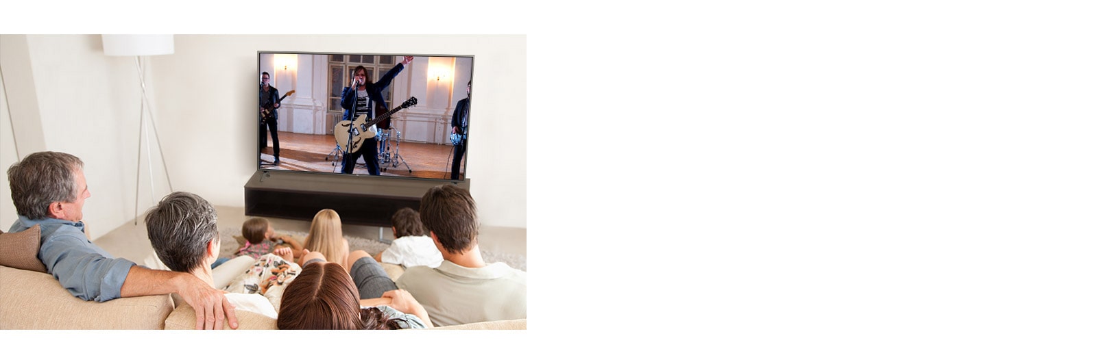 La famiglia di sette membri si riunì in salotto per guardare un film.  Una band sta suonando sullo schermo della TV.