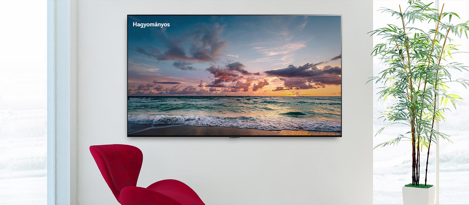 Egy falra rögzített nagyképernyős TV, előtte egy piros szék. A képernyőn egy tengerpart látható, amelyek finoman mosnak a hullámok. Balról jobbra görgetve láthatóvá válik a kép hagyományos LCD képernyőn, valamint egy LG QNED MiniLED képernyőn, mutatva a színkülönbséget.