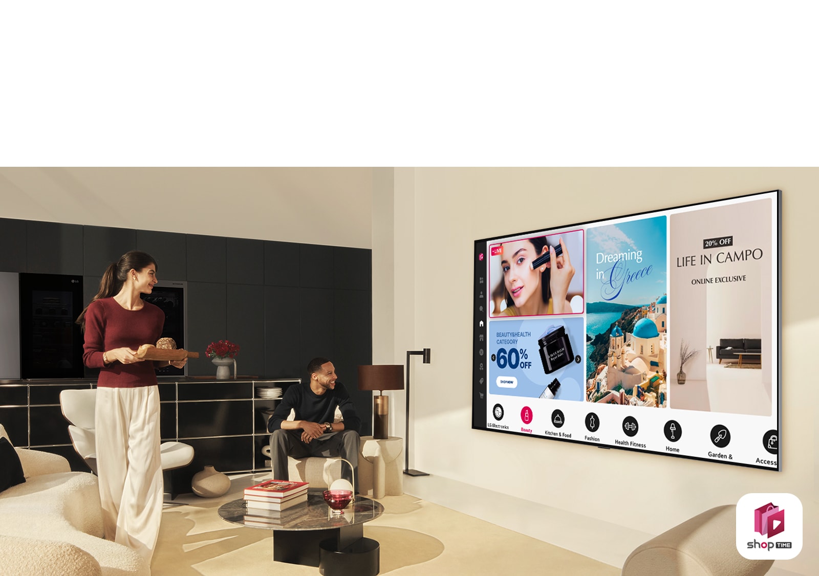 זוג צופה בערוצי הקניות הביתיים ב-LG TV גדולה התלויה על הקיר בחלל מגורים מודרני. 