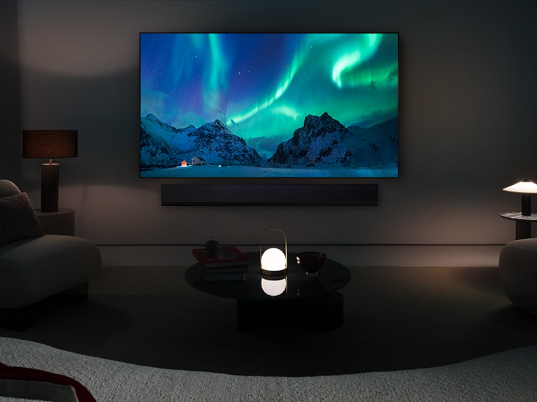 טלוויזיית LG OLED והסאונד בר של LG בחלל מגורים מודרני בשעות הלילה. תמונת הזהר הצפוני על פני המסך מוצגת ברמת בהירות אופטימלית.