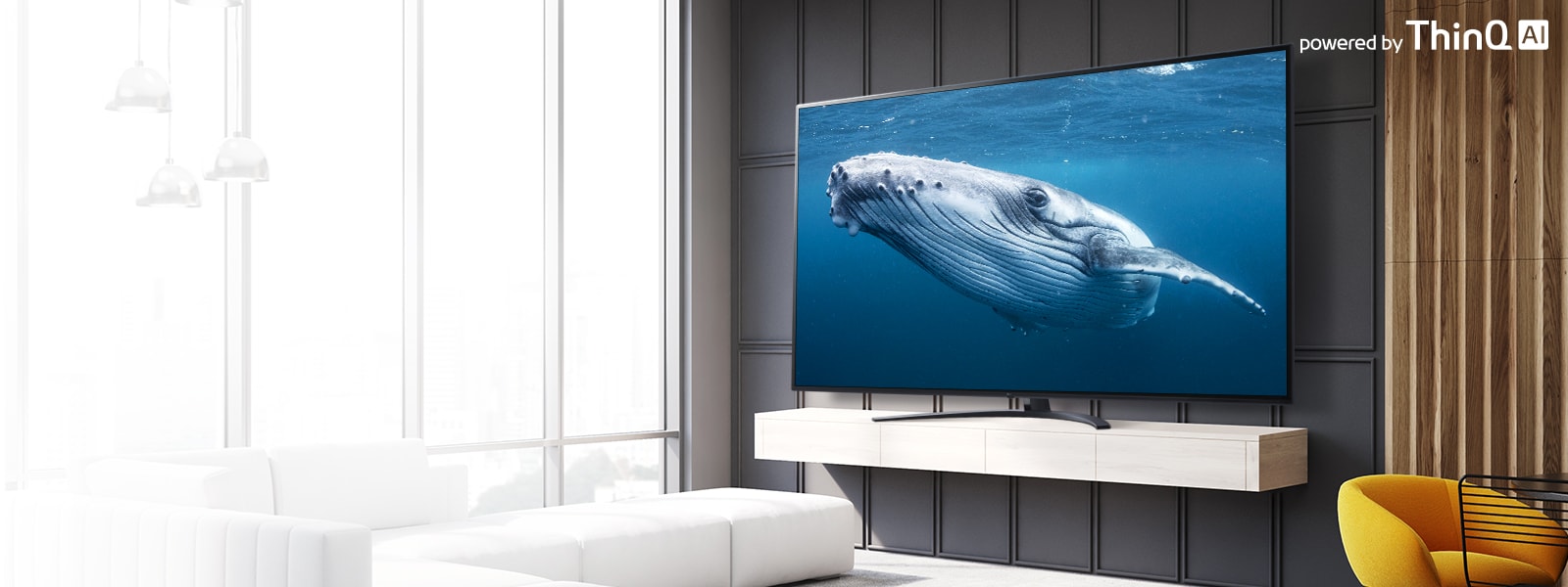 בתוך סלון, יש מסך טלוויזיה גדול המציג תמונה של לווייתן גדול בים. בתמונה מוצג מסך טלוויזיה גדול בצד שמאל והלוגו ‚בהפעלת ThinQ AI‘ מופיע בחלק הימני העליון.