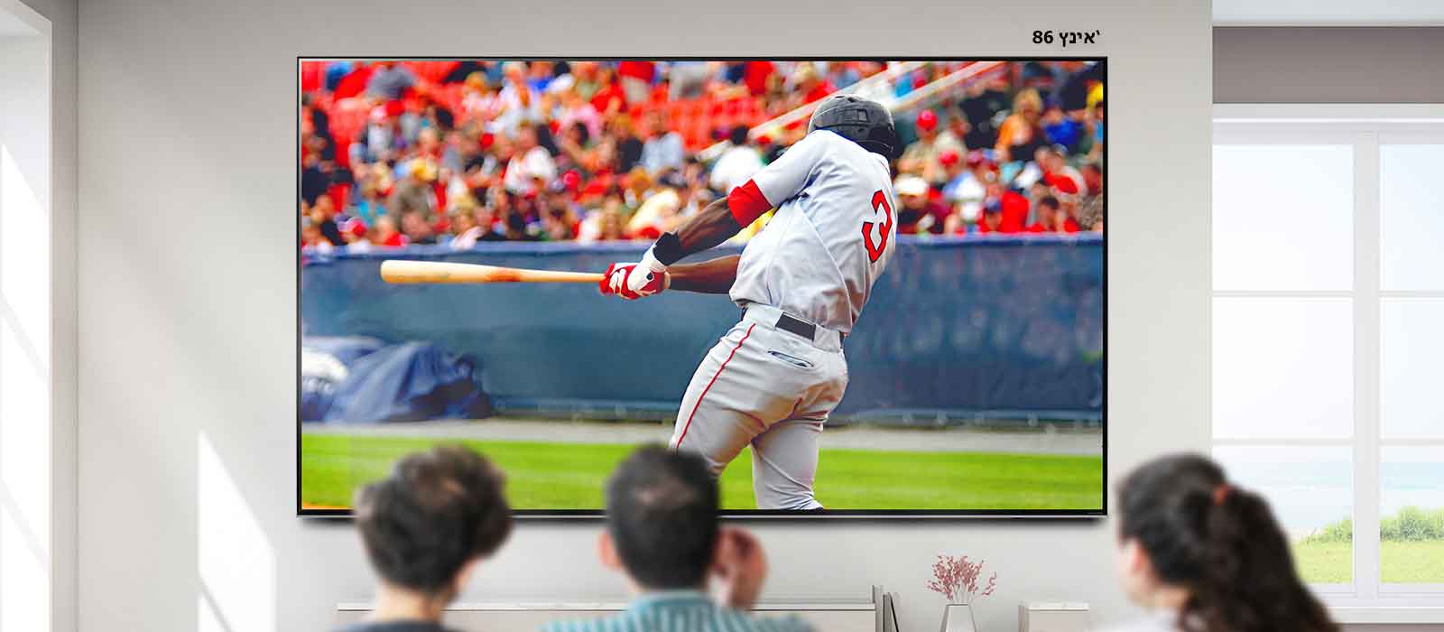 תמונה הניתנת לגלילה של שלושה אנשים הצופים במשחק בייסבול בטלוויזיה גדולה תלויה על קיר. עם הגלילה משמאל לימין, המסך גדל.