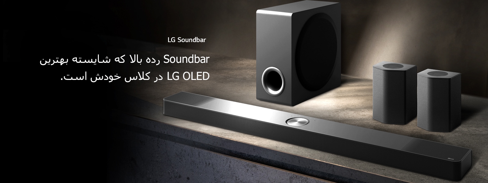 LG Soundbar، بلندگوهای پشت، و ساب‌ووفور در نمایی زاویه‌دار روی یک قفسه چوبی قهوه‌ای در اتاقی سیاه و مملو از تاریکی قرار دارند که نور تنها روی سیستم صوتی را روشن کرده است.