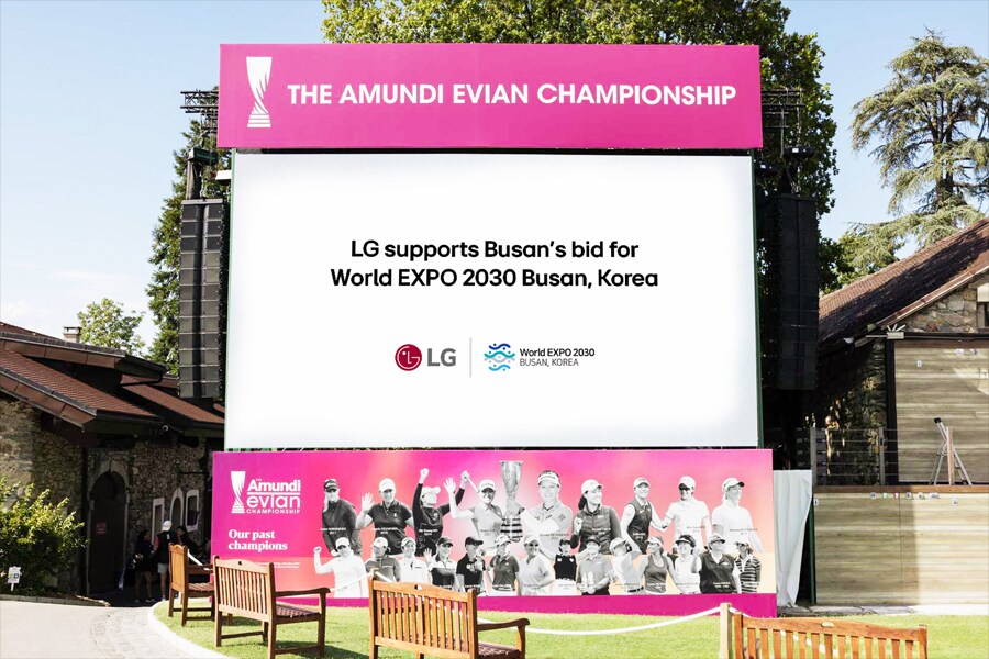 Un grande cartellone rosa in un parco che promuove l’Amundi Evian Championship e il supporto di LG per la candidatura di Busan alla World Expo 2030.