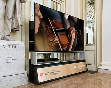 Una TV 8K OLED di LG SIGNATURE, che riproduce l'orchestra  sul suo schermo, è in esposizione al Teatro alla Scala.