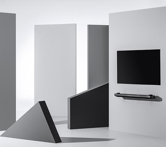 LG SIGNATURE oled tv w sospeso a parete circondato da figure geometriche