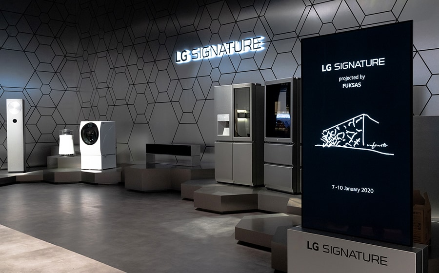 Il pannello illustrativo della linea LG SIGNATURE al CES 2020 è posto sul lato destro dell'immagine, mentre alcuni dei prodotti della suddetta gamma sono collocati sulla sinistra.