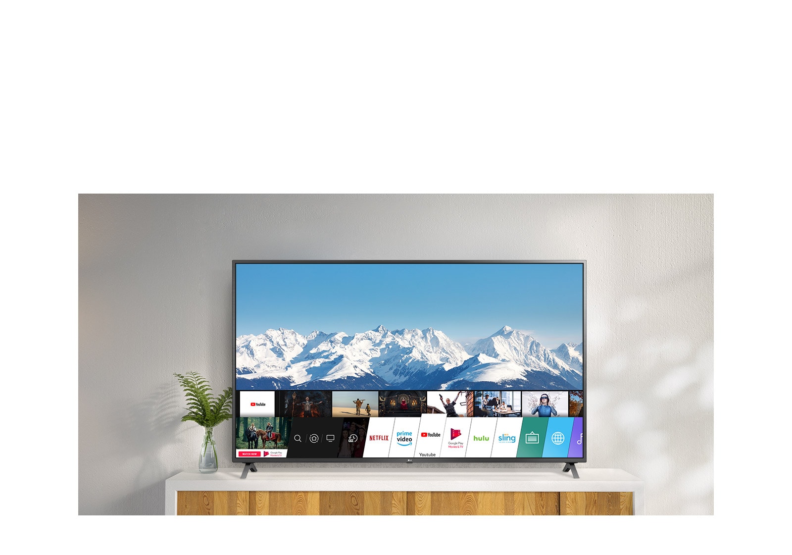 TV debout sur un support blanc contre un mur blanc. L'écran du téléviseur affiche l'écran d'accueil avec webOS.