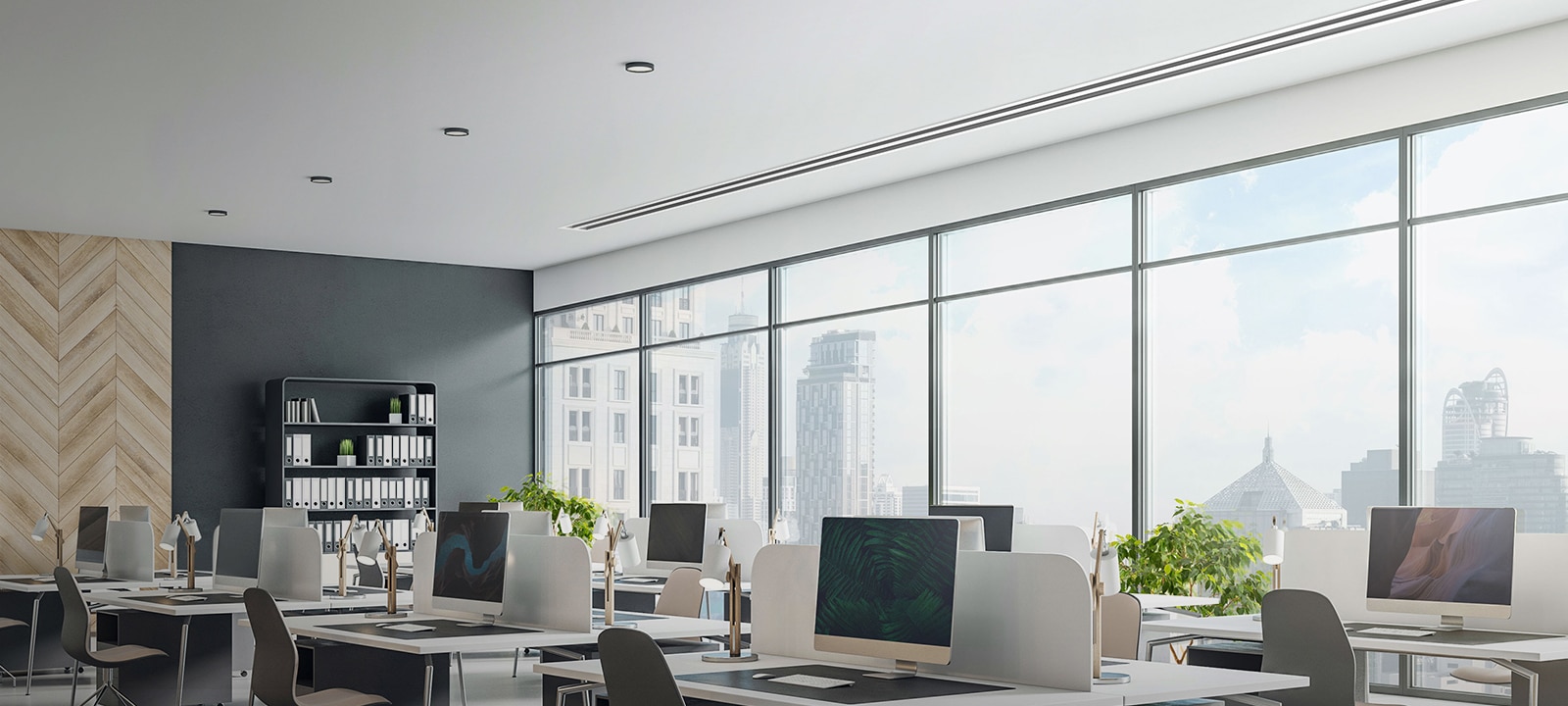 In an office with floor-to-ceiling windows showcasing the city skyline, desks, and computers, the LG Ceiling Concealed Duct maintains the office's clean and modern aesthetic.