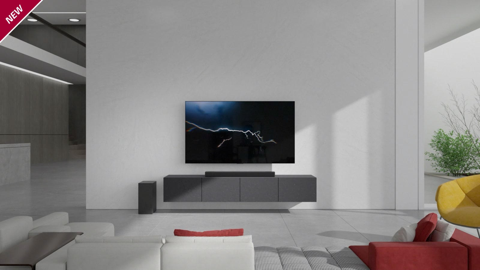 The Sound Bar is placed on a gray cabinet with the TV mounted on the living room wall. A wireless subwoofer is placed on the floor on the left, with sunlight shining in from the right side of the image. A long red and white sofa is placed in front of the TV and sound bar. The "New" label is visible in the upper left corner.