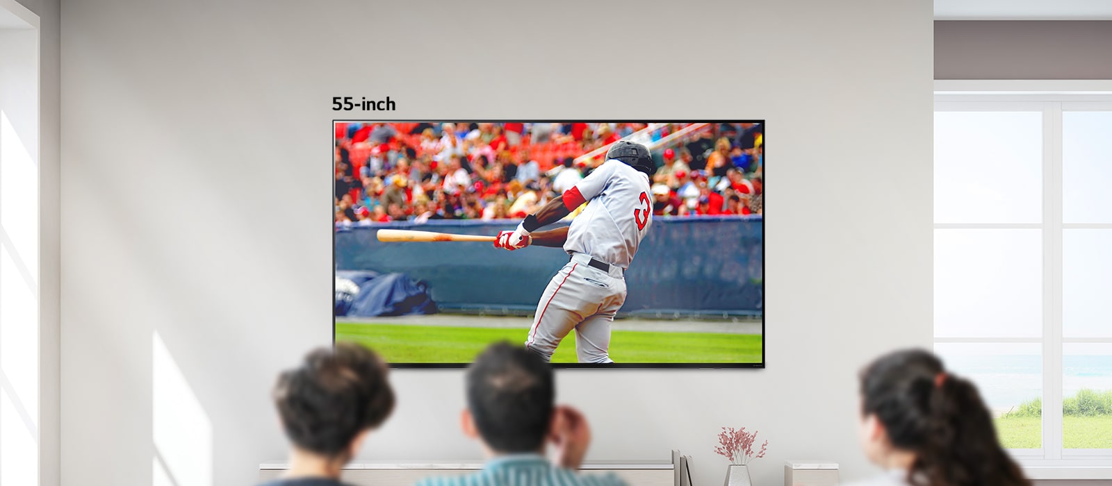 Een scrolbaar beeld van drie mensen die honkbal kijken op een grote aan de muur gemonteerde tv. Als je van links naar rechts scrolt, wordt het scherm groter.