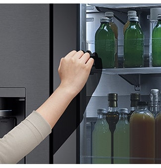 Vedere frontală a unui frigider InstaView cu sticlă neagră, cu lumina aprinsă în interior. Mâini atingând ecranul InstaView.