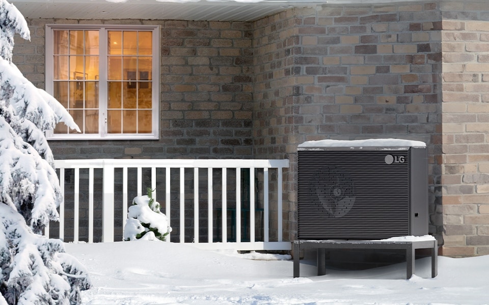 snowy landscape, showcasing a Therma V R290 Monobloc heat pump and a tree nearby