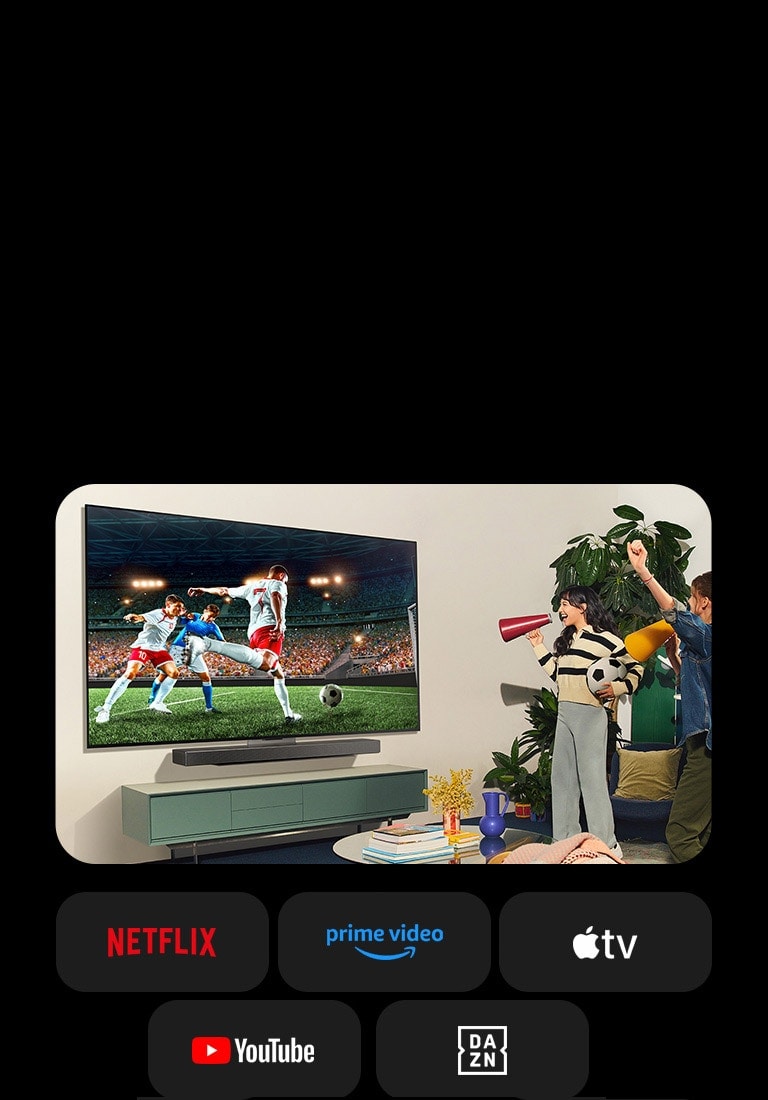 Dve žene gledaju fudbalsku utakmicu u udobnom životnom prostoru. Jedna žena drži fudbalsku loptu i obe navijaju za svoj tim pored žutih i crvenih zvučnika. Sledeći logoi se prikazuju ispod. Netflix, Amazon Prime Video, Apple TV, YouTube, ESPN i DAZN.