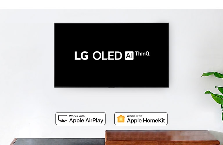 Настенный телевизор, показывающий логотип LG OLED AI ThinQ на черном фоне