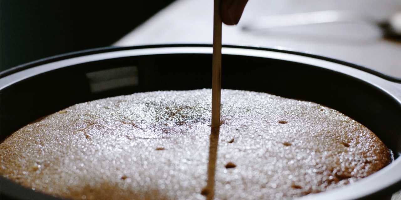 Проделывание дырочек в процессе приготовления гранатового торта с полентой