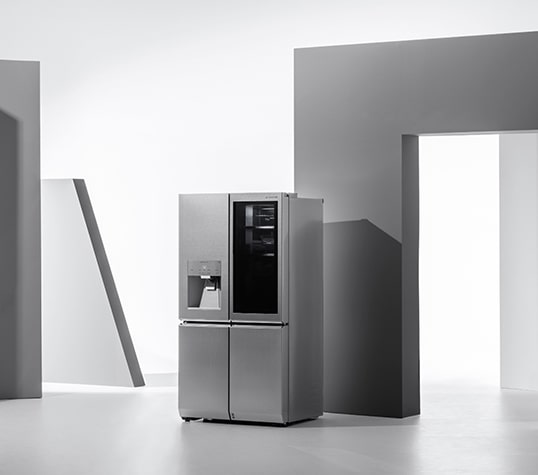 Холодильник LG SIGNATURE стоит в окружении геометрических фигур