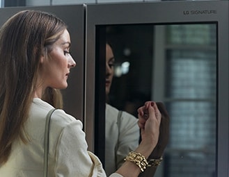 Оливия Палермо постукивает по стеклянной панели InstaView холодильника LG SIGNATURE.
