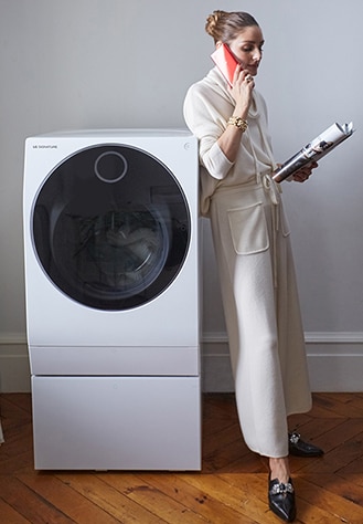 Оливия Палермо ждет окончания цикла стиральной машины LG SIGNATURE, занимаясь другими делами.
