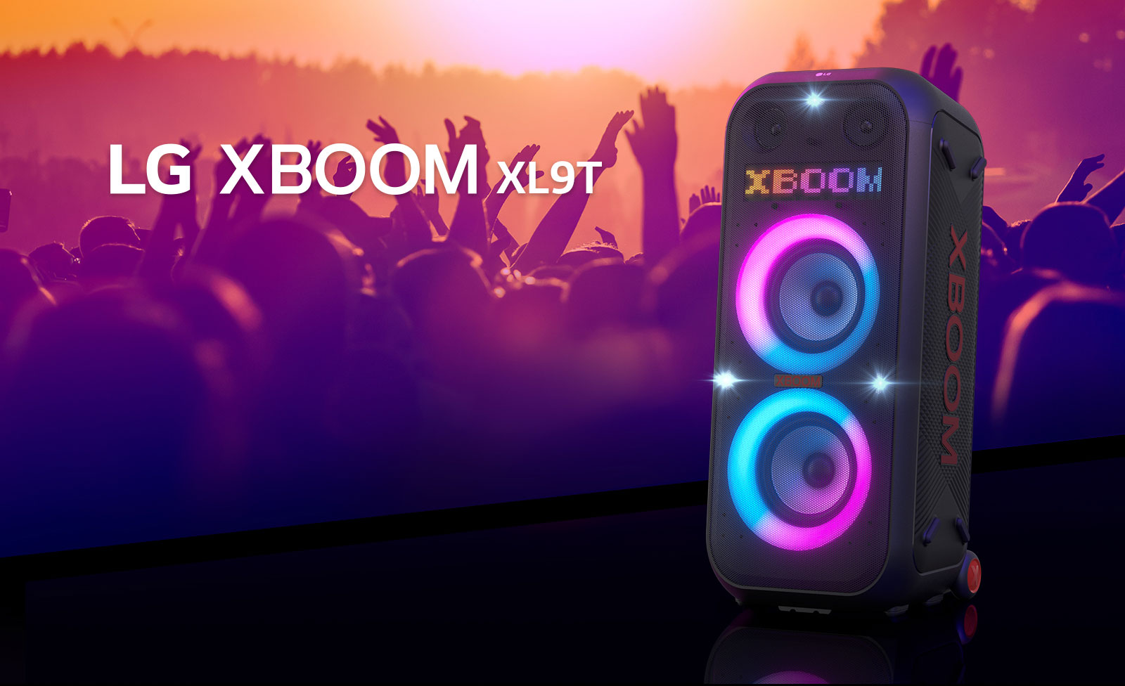 Diagonálny pohľad na reproduktor LG XBOOM XL9T umiestnený na povrchu. Je zapnuté viacfarebné osvetlenie a na displeji sa zobrazuje slovo „XBOOM“. Za reproduktorom vidieť siluety ľudí, ktorí si užívajú zábavu.