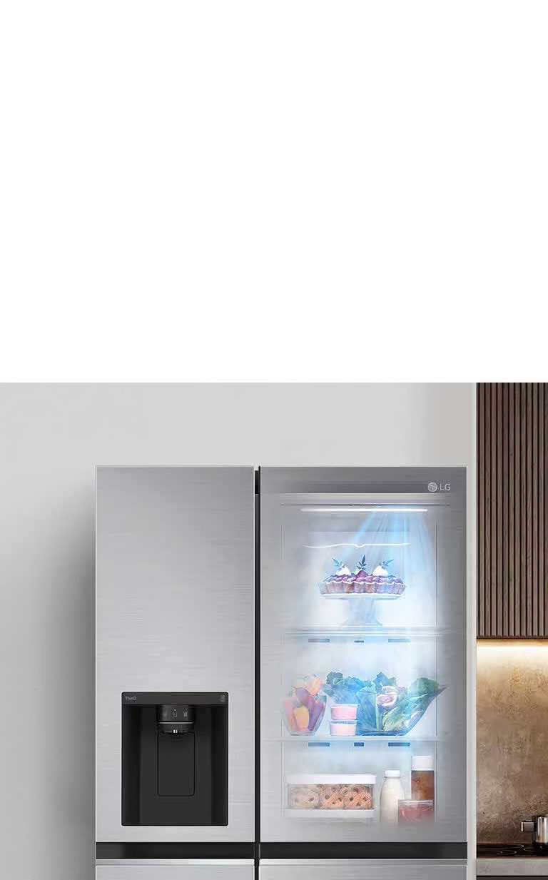 Pohľad spredu na chladničku so zapnutým svetlom vo vnútri. Obsah chladničky vidieť cez priehľadný otvor InstaView v dverách. Modré svetelné lúče funkcie DoorCooling vyžarujú nadol a prechádzajú cez obsah chladničky.
