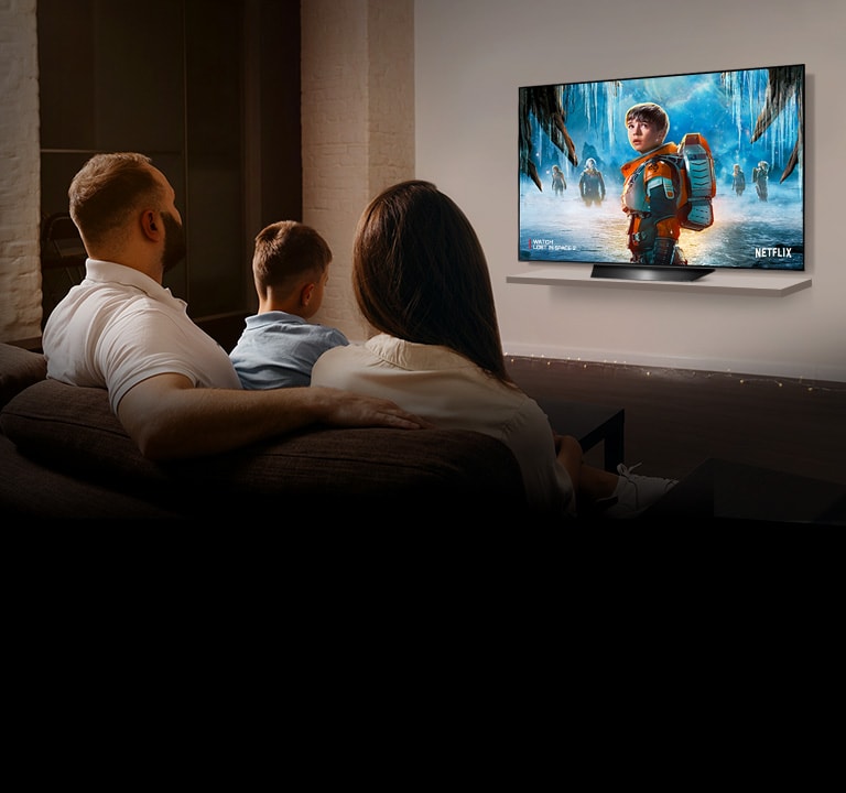 Pár sediaci na pohovke v obývacej izbe sleduje na televízore romantický film