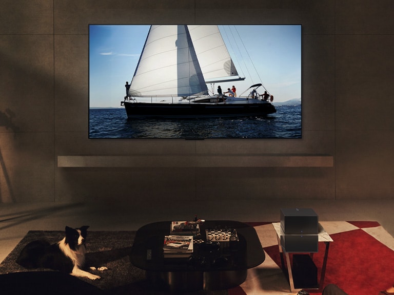 夜晚時間位於現代客廳空間的 LG OLED evo M4 和 LG Soundbar。以理想亮度顯示帆船航行於海洋中的螢幕影像。