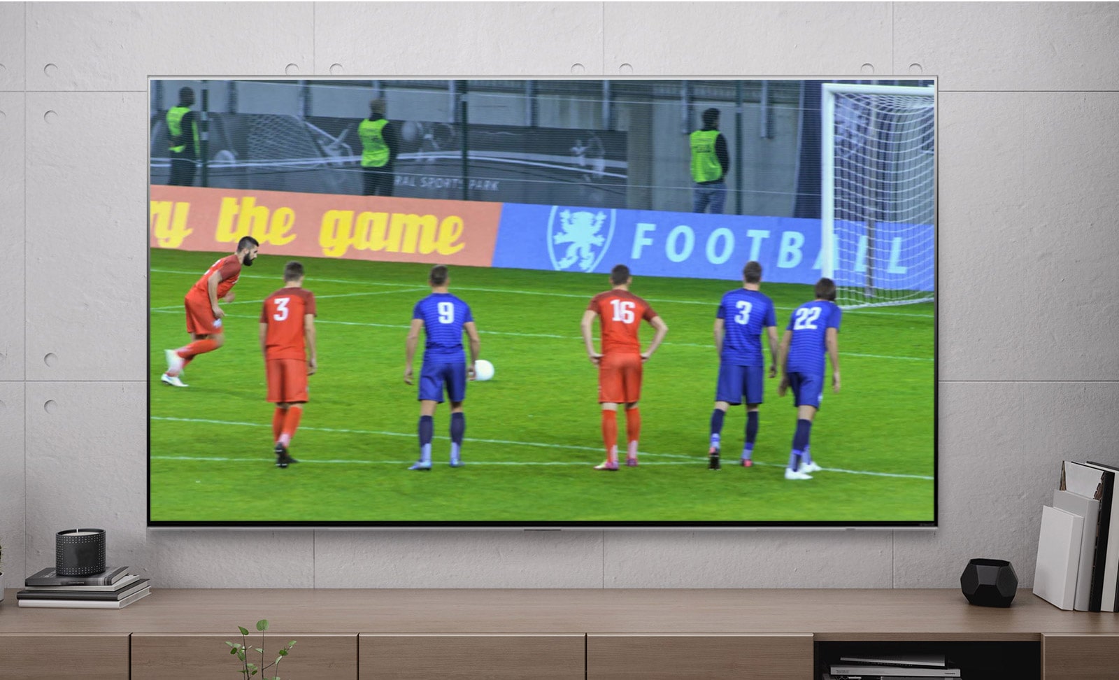 Екран телевізора, на якому показано футболіста, який пробиває пенальті (відтворення відео)