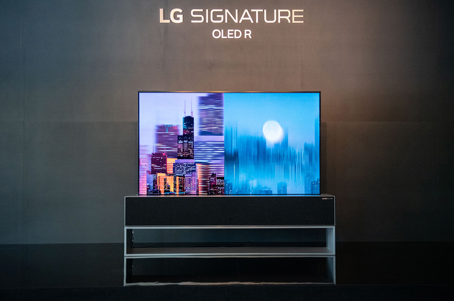 LG SIGNATURE Rollable OLED R rollable TV with nighttime cityscape images displayed