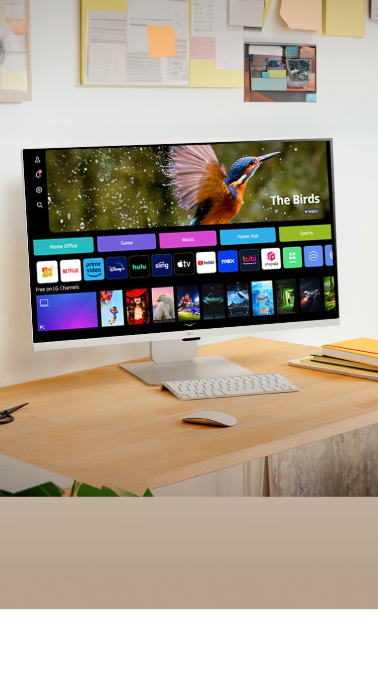 LG Smart Monitor on a wooden desk in a bright, plant-filled home office.