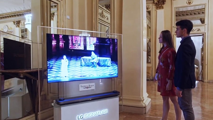 A man and woman are watching the Rigoletto on LG SIGNATURE OLED 8K TV.