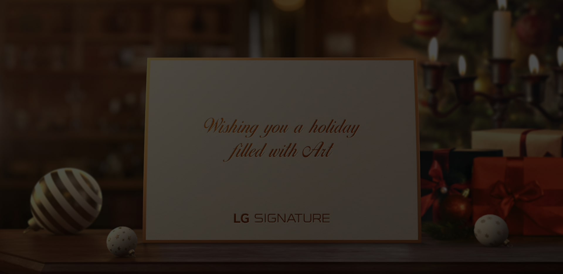 A white holiday card from the LG SIGNATURE is placed on the desk.