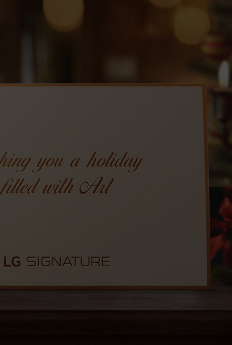 A white holiday card from the LG SIGNATURE is placed on the desk.