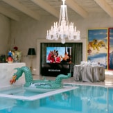 LG SIGNATURE OLED TV 77 has a scene from John Legend's 'You Deserve It All' music video up. Surrounding it are interior adornments for the event.