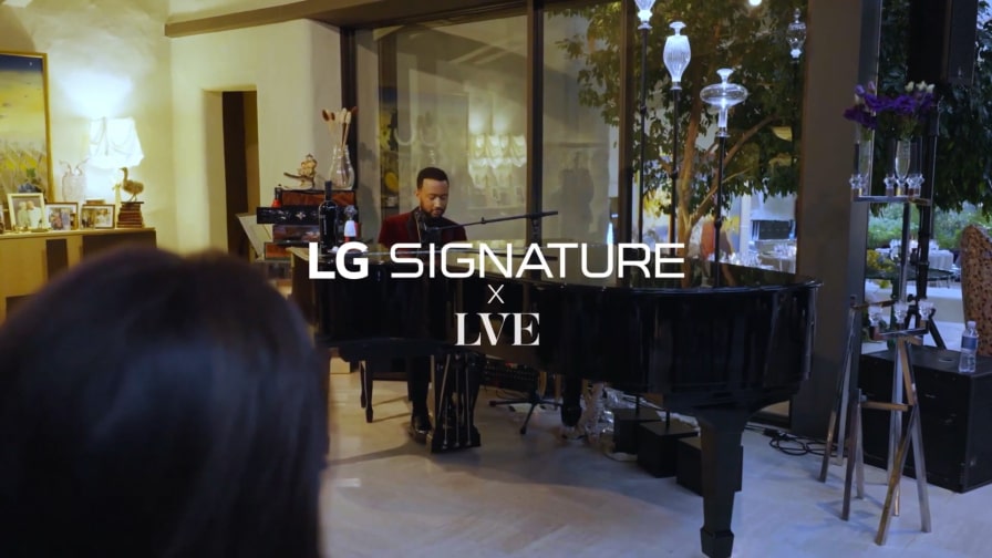 John Legend is playing the piano at the LVE wine event.