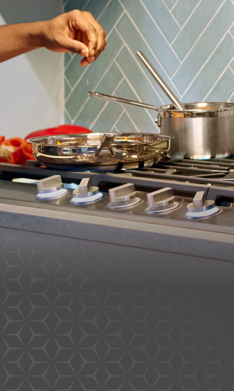 A person cooking on a sleek gas stove, surrounded by modern kitchen appliances, with a visible LG logo and a promotional tagline 'Complete your space with a sleek cooktop'.