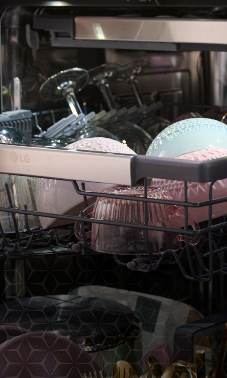 Open LG dishwasher loaded with various dishes, promoting the 'Elevated design. Efficient clean.' features of LG Studio dishwashers.