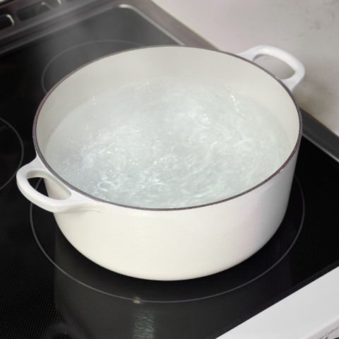 Pot of boiling water on an induction cooktop, highlighting the fast heating and energy efficiency of LG Studio appliances.