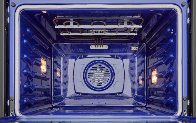 An empty LG Studio oven with its door open, showing the bright blue, clean interior. The image highlights the oven’s easy-to-clean design with advanced cleaning features.