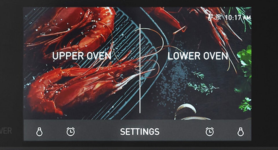 A close-up view of an LG oven control screen displaying ‘Upper Oven’ and ‘Lower Oven’ settings, with an image of shrimp cooking, emphasizing split cooking zones for different meals.