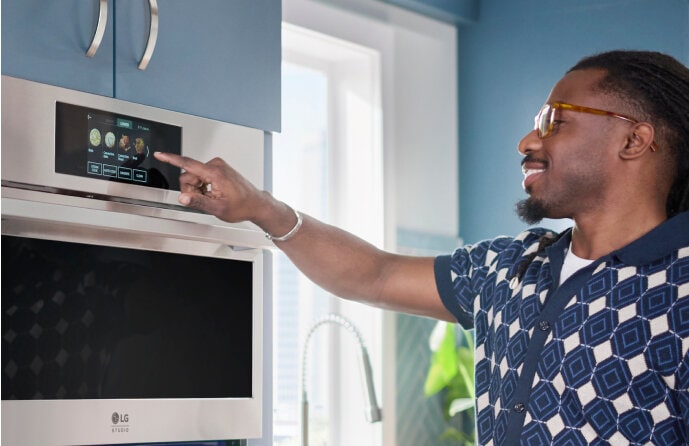 A man selecting cooking options from an LG Studio