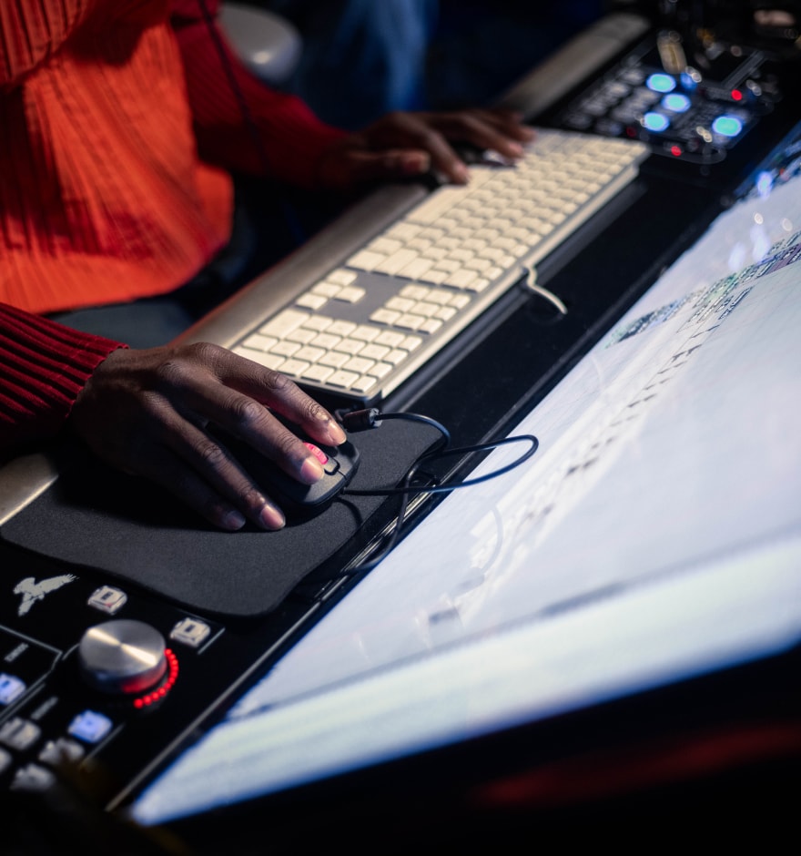 Will.i.am hand holding a mouse in front of a computer screen