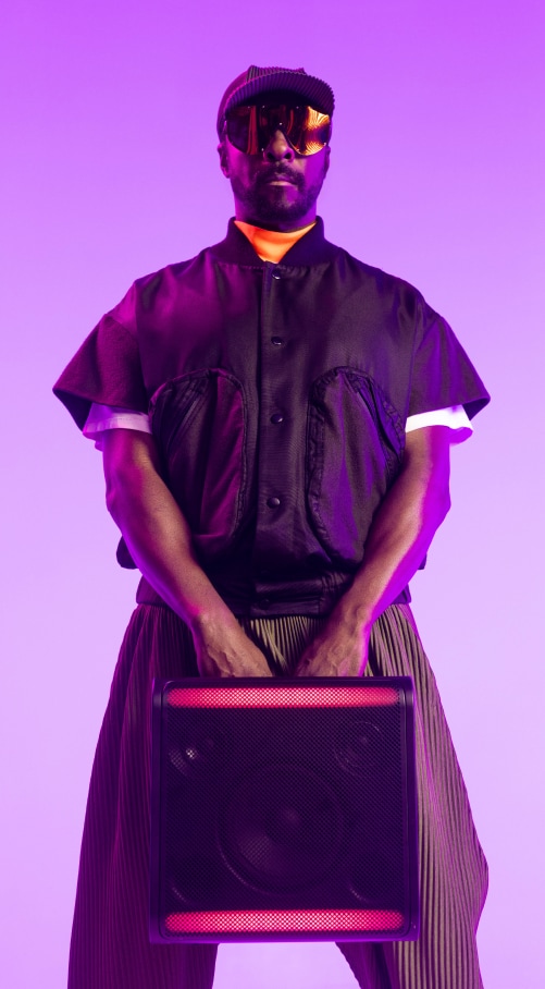 Will.i.am carrying an xboom speaker with both hands