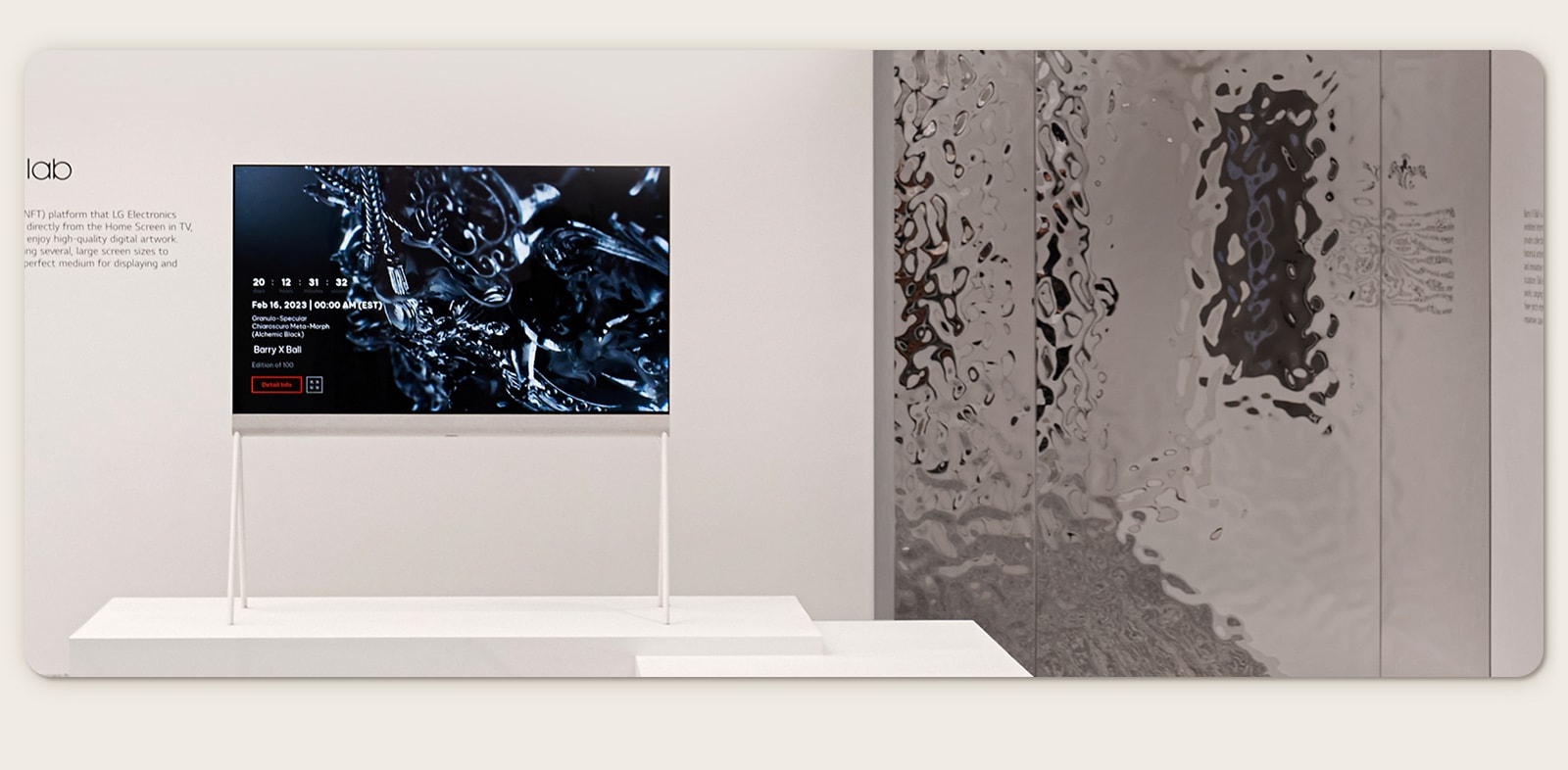 LG OLED Easel trong căn phòng màu trắng chiếu tác phẩm nghệ thuật số về một bức tượng điêu khắc màu đen trên màn hình. Một tác phẩm điêu khắc thực tế màu bạc ở phía bên phải của TV cho thấy hình ảnh phản chiếu của căn phòng. 