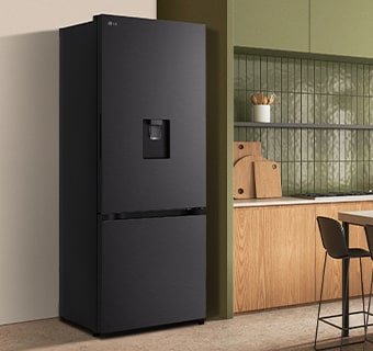 Tủ lạnh LG ngăn đá dưới màu đen hiện đại có cửa rót nước được lắp đồng bộ bên cạnh bàn bếp bằng gỗ.