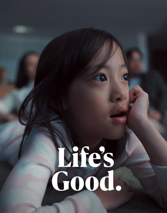 Một cô gái trẻ đang xem LG OLED T với vẻ mặt kinh ngạc.